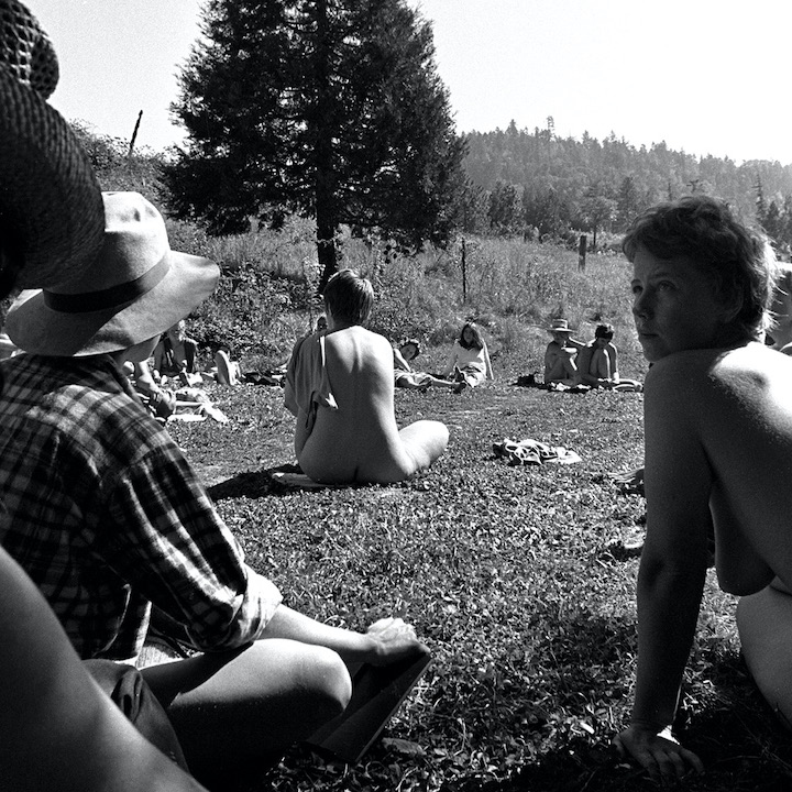 Black and white photo: Many women seated outdoors.